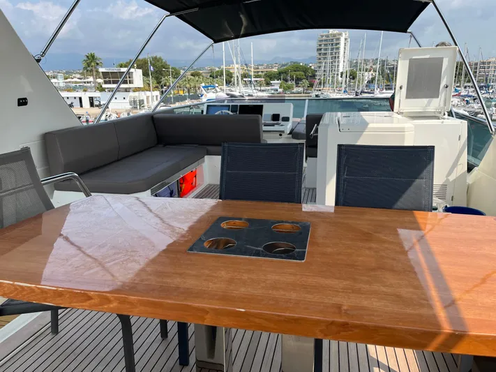  Yacht Photos Pics Luxurious 2017 Prestige 680 yacht deck with seating and dining area in a marina setting.