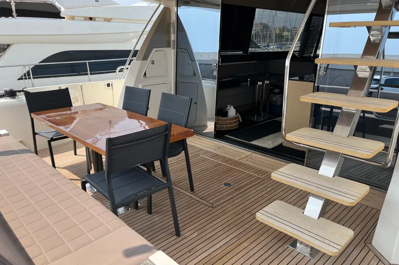  Yacht Photos Pics Luxury yacht deck with dining table, chairs, and staircase; Prestige 680, 2017 model.