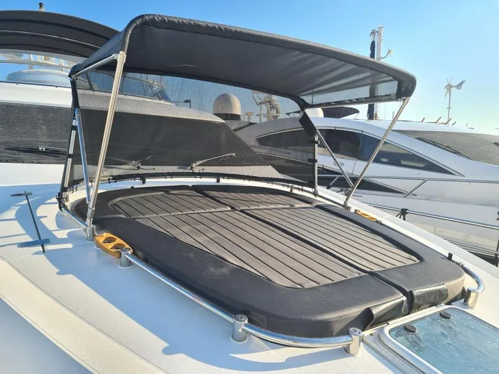  Yacht Photos Pics Prestige 680 yacht sunbathing area with canopy, 2017 model, docked under clear blue sky.