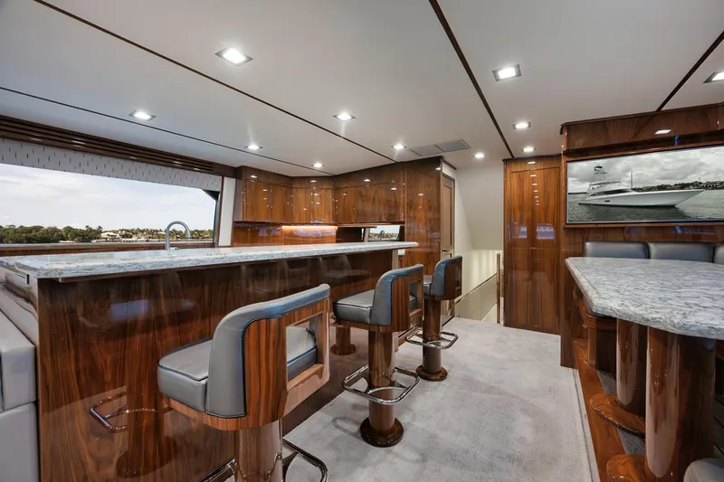  Yacht Photos Pics Luxurious interior of 2019 Viking 80 Convertible yacht with elegant wood finishes.