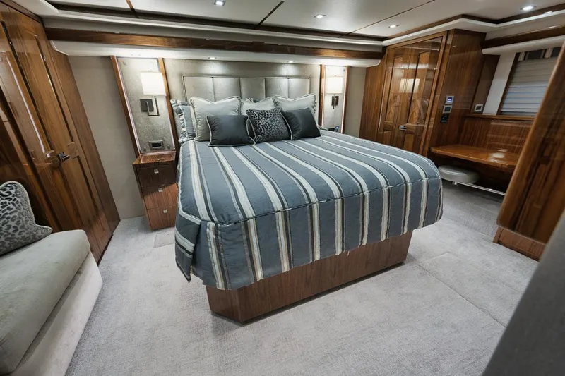  Yacht Photos Pics Luxurious bedroom interior of 2019 Viking 80 Convertible yacht with striped bedding.
