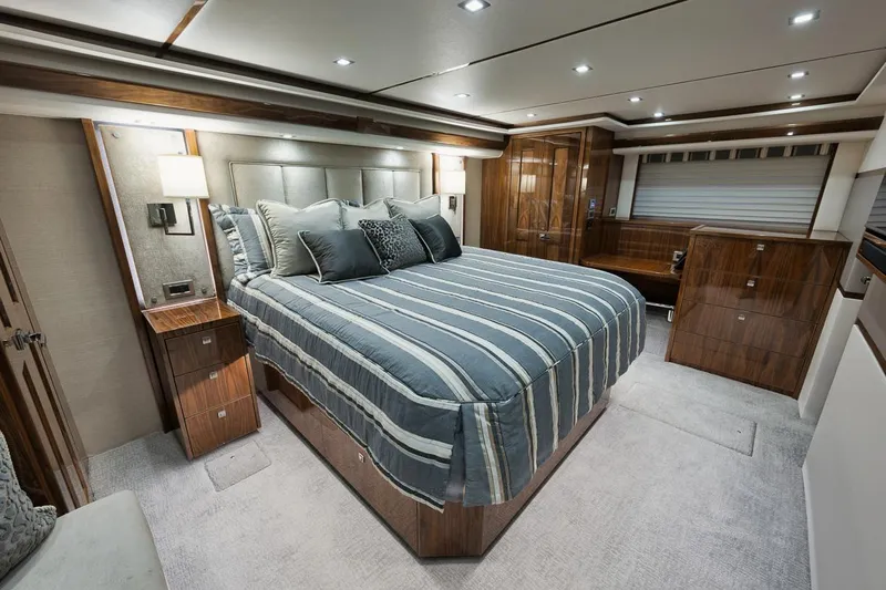  Yacht Photos Pics Luxurious bedroom interior of 2019 Viking 80 Convertible yacht with striped bedding.