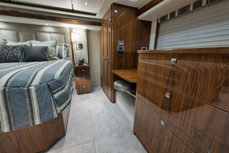  Yacht Photos Pics Luxurious interior of 2019 Viking 80 Convertible yacht bedroom with wood finishes.