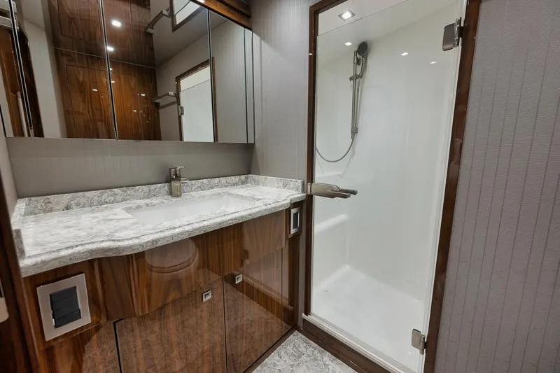  Yacht Photos Pics Luxurious bathroom in 2019 Viking 80 Convertible yacht with marble countertop and glass shower.