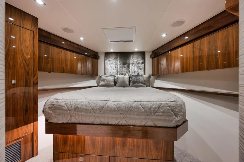  Yacht Photos Pics Luxurious bedroom interior of 2019 Viking 80 Convertible yacht with wood paneling.