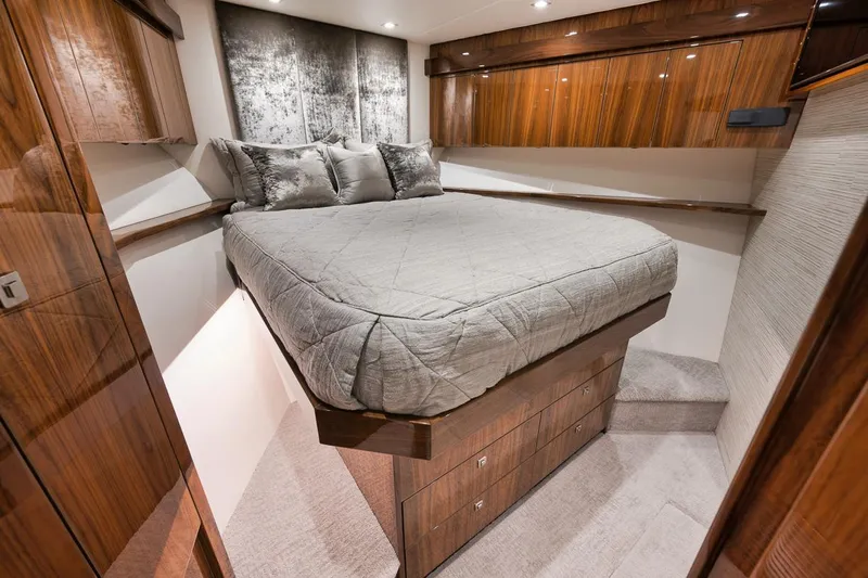  Yacht Photos Pics Luxurious bedroom interior of 2019 Viking 80 Convertible yacht with elegant wood finishes.