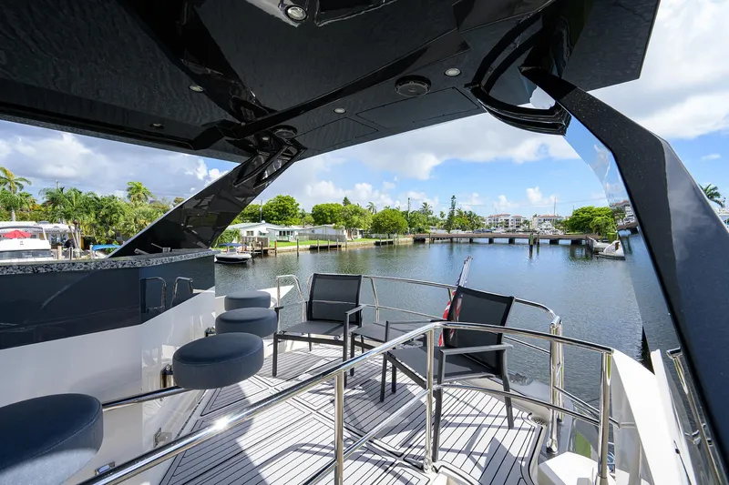 No Name 66 Marquis Yacht Photos Pics 2017 Marquis 660 Sport Yacht deck with seating, overlooking serene waterfront and lush greenery.