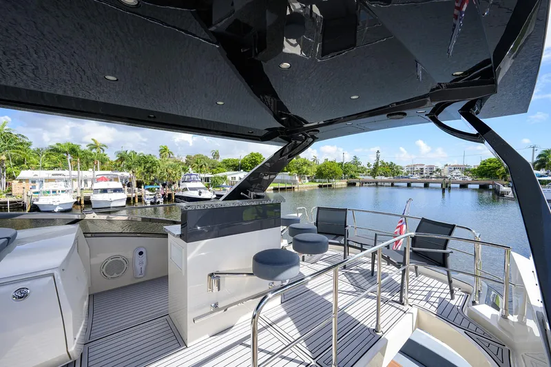 No Name 66 Marquis Yacht Photos Pics 2017 Marquis 660 Sport Yacht deck with seating, overlooking marina and lush greenery.