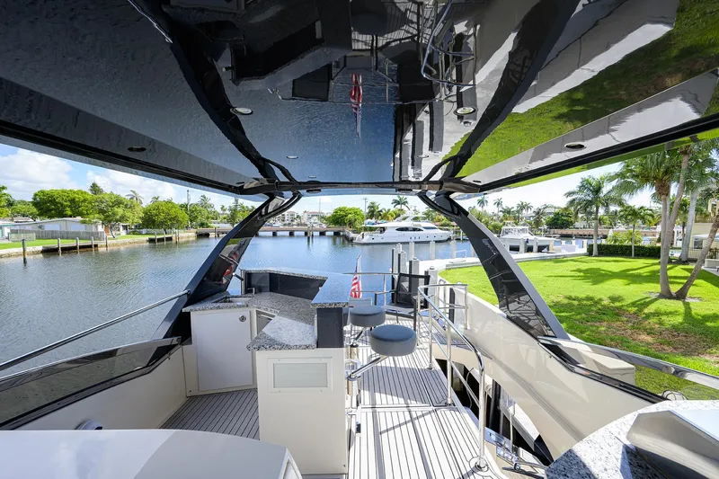 No Name 66 Marquis Yacht Photos Pics 2017 Marquis 660 Sport Yacht deck with modern design, overlooking serene waterfront and lush greenery.