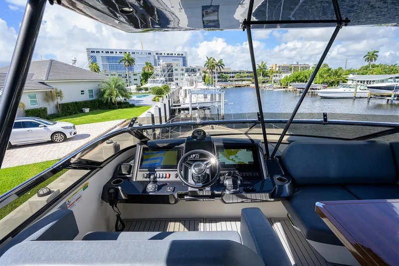 No Name 66 Marquis Yacht Photos Pics 2017 Marquis 660 Sport Yacht cockpit with modern controls, overlooking marina and waterfront homes.