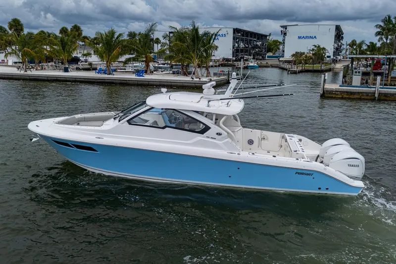  Yacht Photos Pics 2023 Pursuit DC 365 Dual Console boat cruising near marina with palm trees.