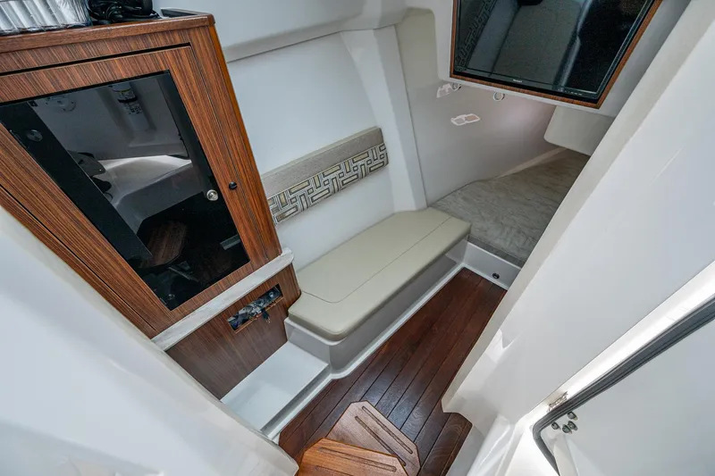  Yacht Photos Pics 2023 Pursuit DC 365 Dual Console cabin interior with wood accents and seating.