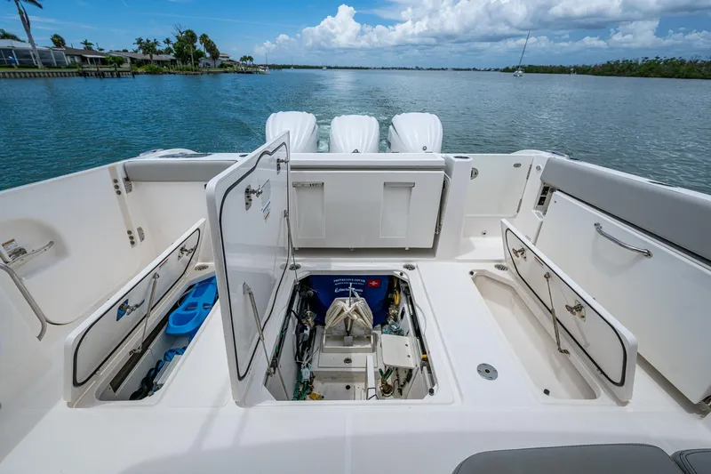  Yacht Photos Pics 2023 Pursuit DC 365 Dual Console boat with open storage compartments on a calm waterway.