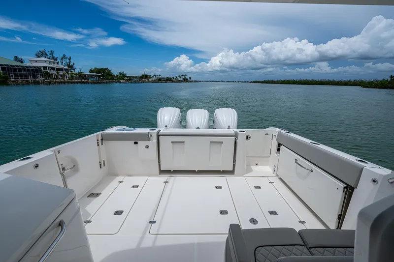  Yacht Photos Pics 2023 Pursuit DC 365 Dual Console boat on calm water, featuring spacious deck and triple engines.