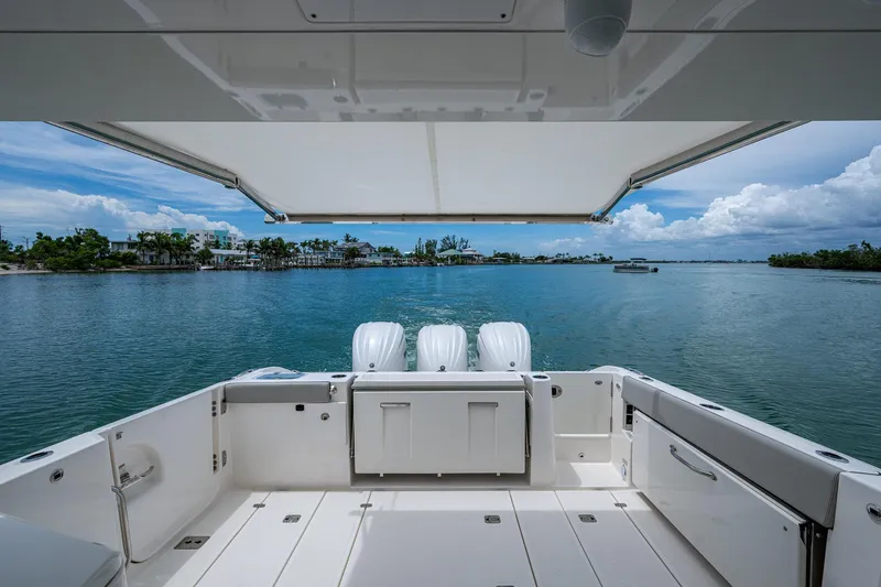  Yacht Photos Pics 2023 Pursuit DC 365 Dual Console boat on serene water with scenic view.