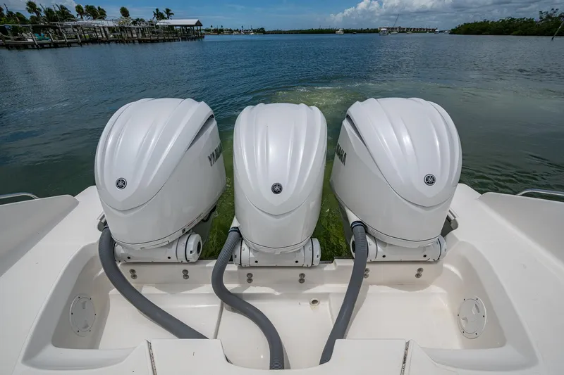  Yacht Photos Pics Triple Yamaha outboard engines on a 2023 Pursuit DC 365 Dual Console boat, docked on calm water.