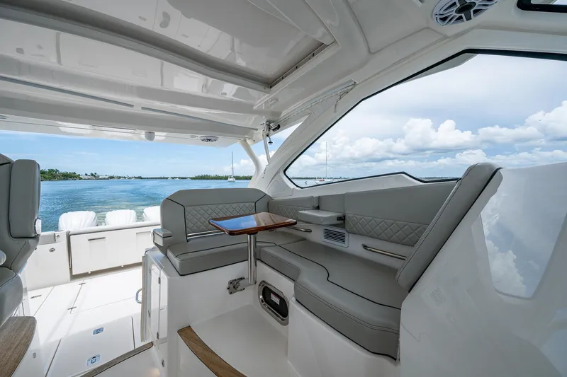  Yacht Photos Pics 2023 Pursuit DC 365 Dual Console interior with seating, table, and ocean view.