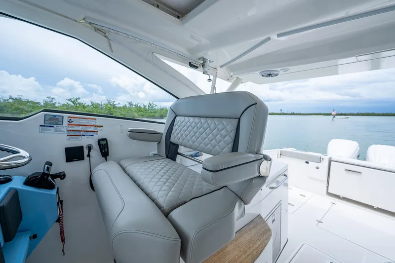  Yacht Photos Pics 2023 Pursuit DC 365 Dual Console boat interior with luxurious seating and scenic water view.
