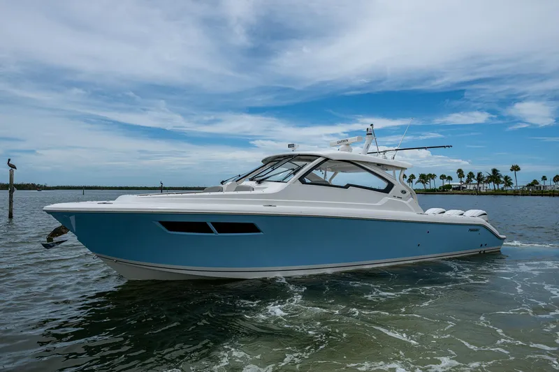  Yacht Photos Pics 2023 Pursuit DC 365 Dual Console boat on calm water under a blue sky.