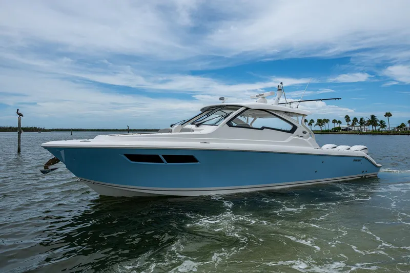  Yacht Photos Pics 2023 Pursuit DC 365 Dual Console boat on calm water under a blue sky.