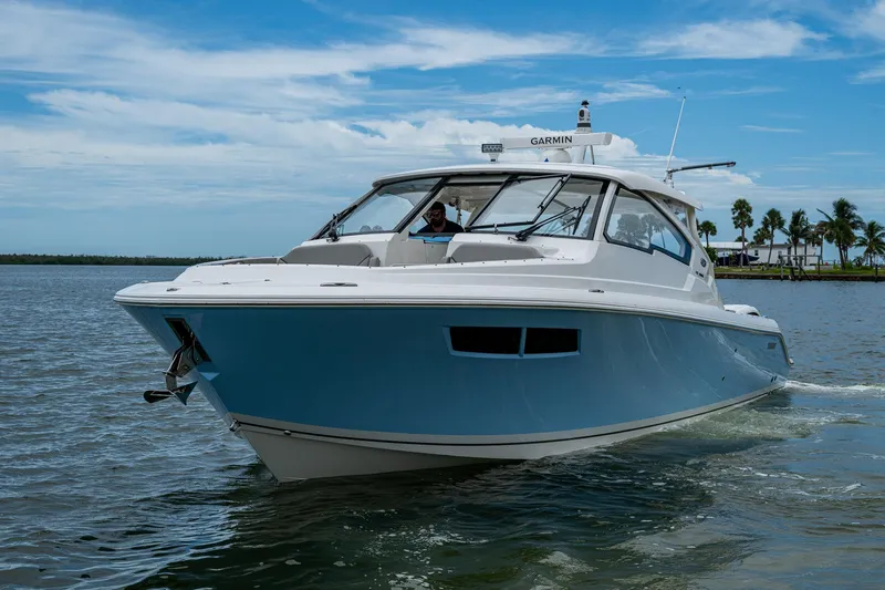  Yacht Photos Pics 2023 Pursuit DC 365 Dual Console boat cruising on a sunny day.