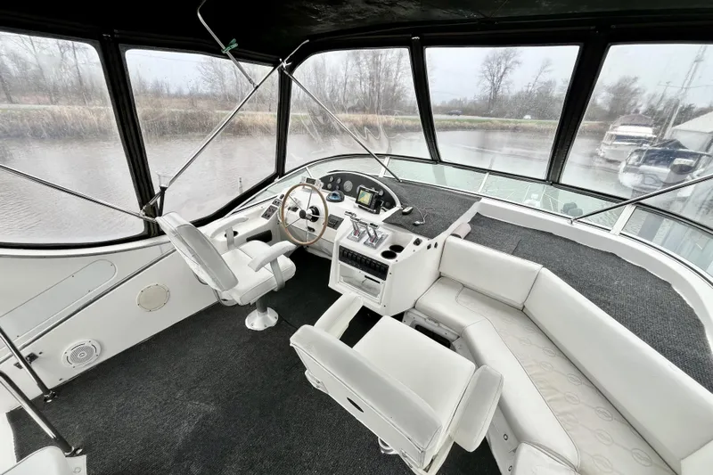  Yacht Photos Pics Interior view of 1996 Bayliner 3988 Motoryacht helm with white seating and steering wheel.