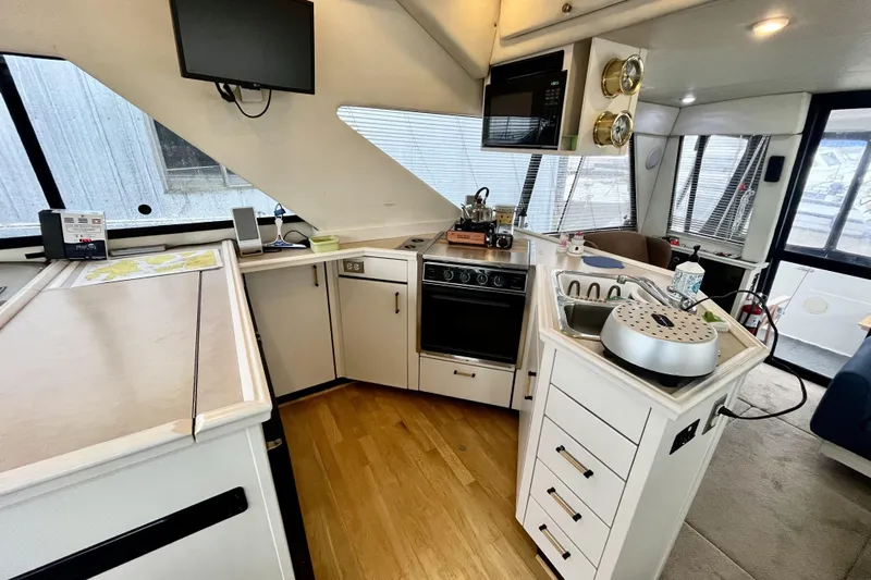  Yacht Photos Pics Interior of 1996 Bayliner 3988 Motoryacht featuring kitchen with stove, sink, and microwave.