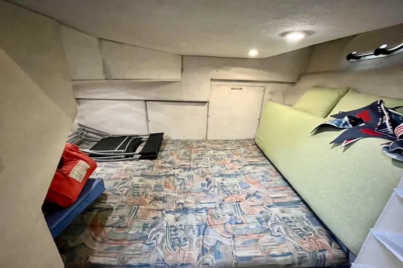  Yacht Photos Pics 1996 Bayliner 3988 Motoryacht cabin interior with patterned bedding and storage space.