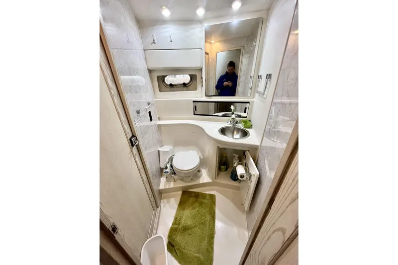  Yacht Photos Pics Bathroom interior of 1996 Bayliner 3988 Motoryacht with modern fixtures and green rug.