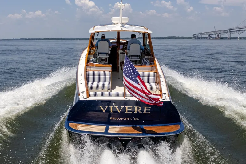 Vivere Yacht Photos Pics Hinckley Picnic Boat 37 MKIII cruising with American flag, 2015 model, open water backdrop.