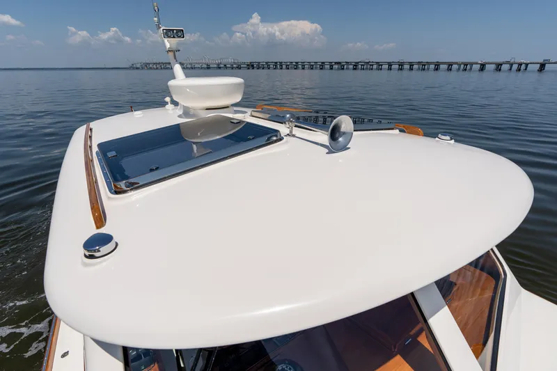 Vivere Yacht Photos Pics 2015 Hinckley Picnic Boat 37 MKIII cruising on calm waters near a bridge.