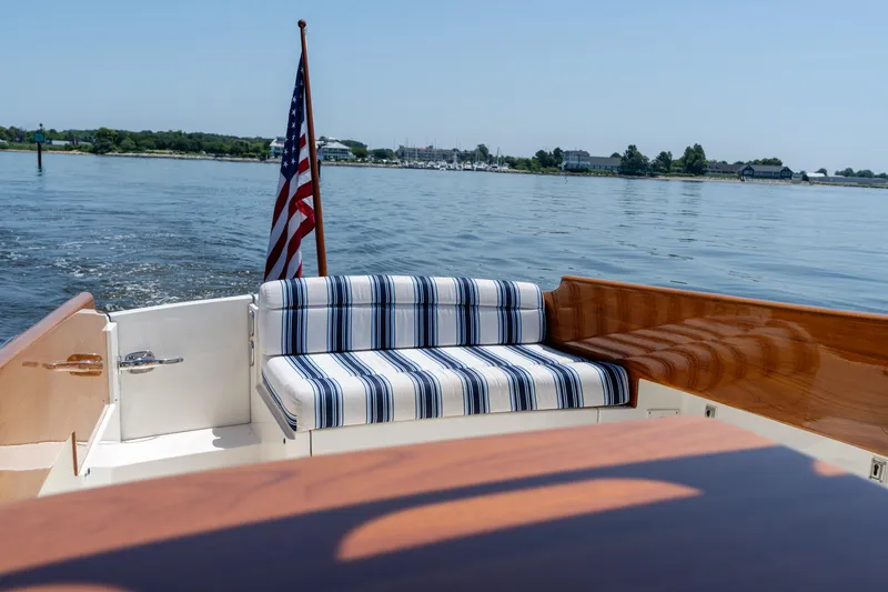 Vivere Yacht Photos Pics 2015 Hinckley Picnic Boat 37 MKIII with striped seating and American flag on calm water.