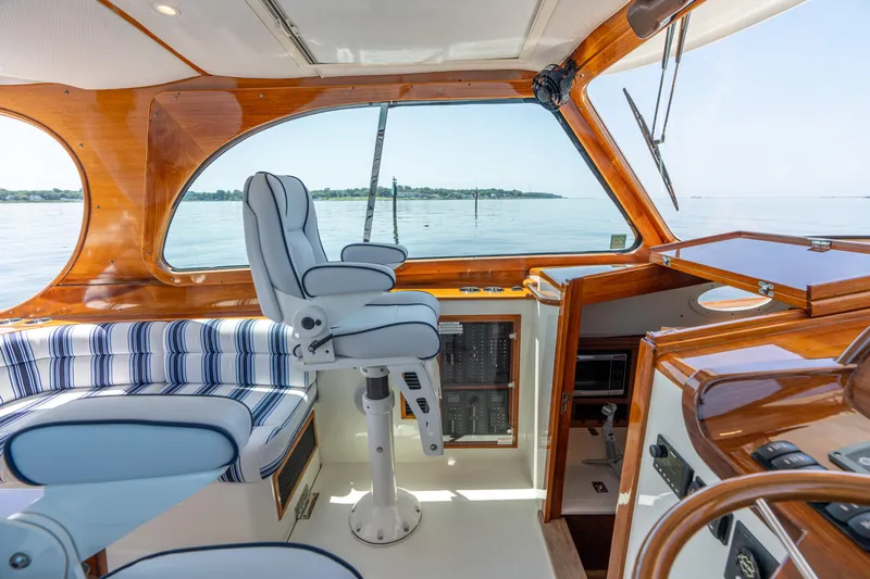 Vivere Yacht Photos Pics Luxurious interior of 2015 Hinckley Picnic Boat 37 MKIII with striped seating and helm.
