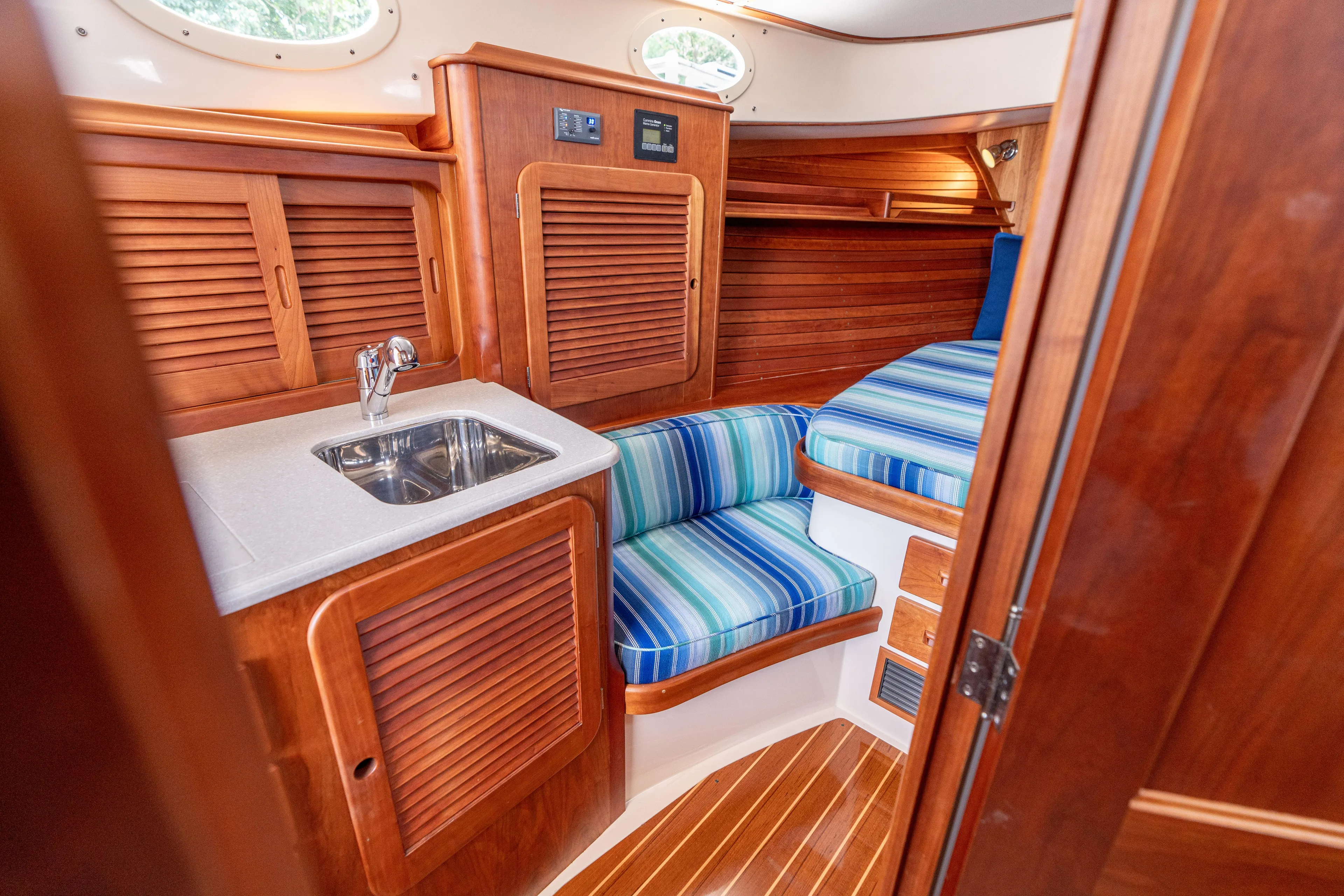 Vivere Yacht Photos Pics Interior of 2015 Hinckley Picnic Boat 37 MKIII with wood finish and striped seating.