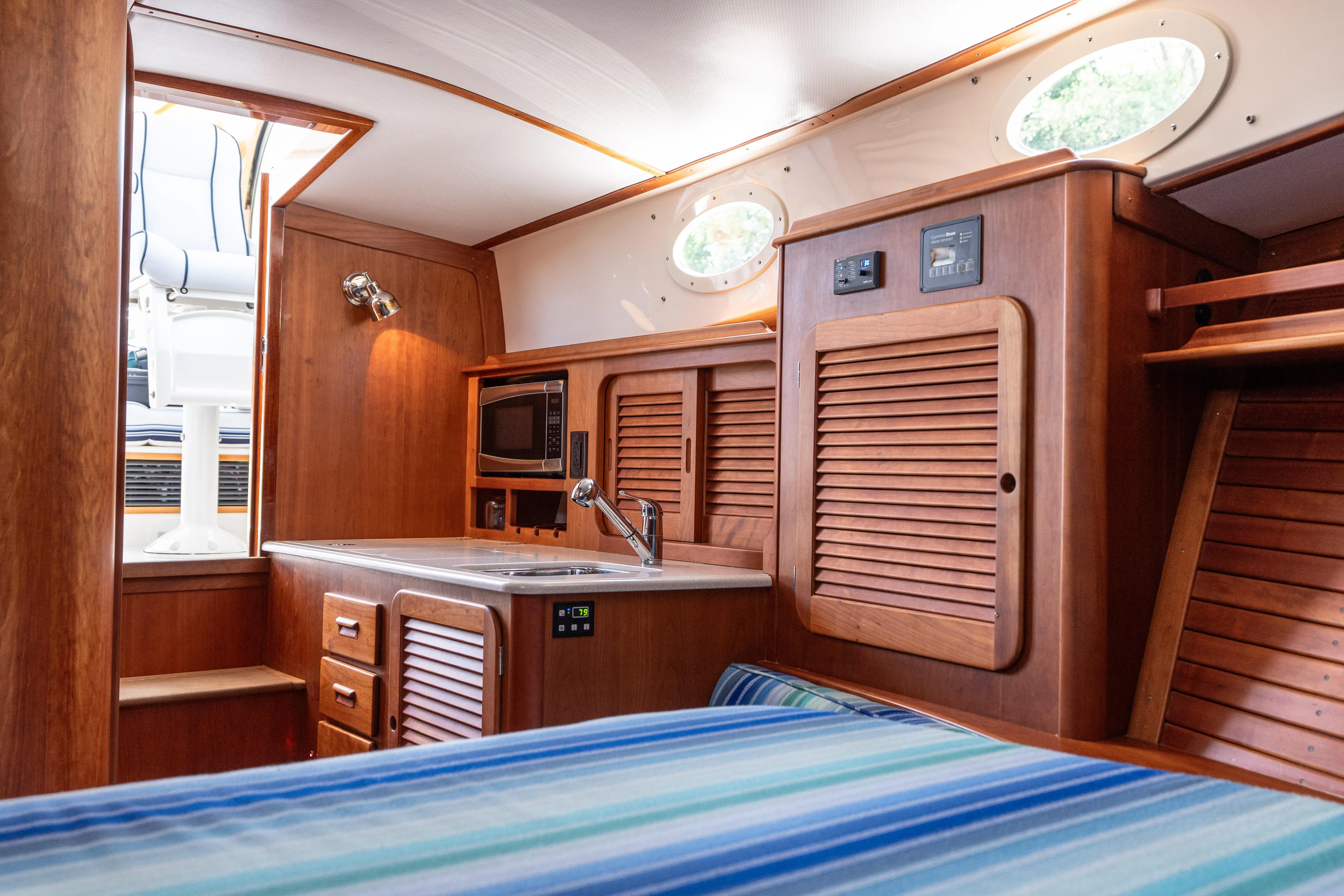 Vivere Yacht Photos Pics Interior of 2015 Hinckley Picnic Boat 37 MKIII with wood cabinetry and compact kitchen area.