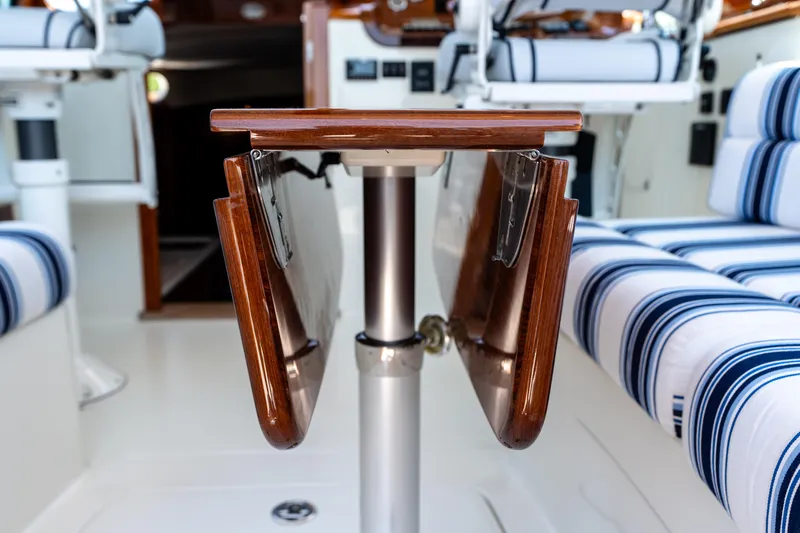 Vivere Yacht Photos Pics Interior of 2015 Hinckley Picnic Boat 37 MKIII with foldable wooden table and striped seating.