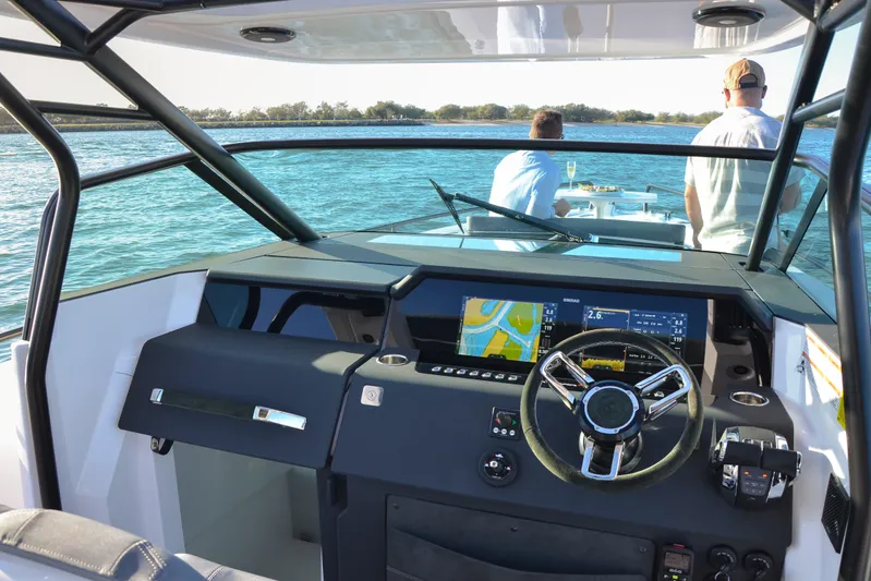  Yacht Photos Pics 2024 Axopar 37 Sun Top boat interior with modern dashboard and steering wheel.