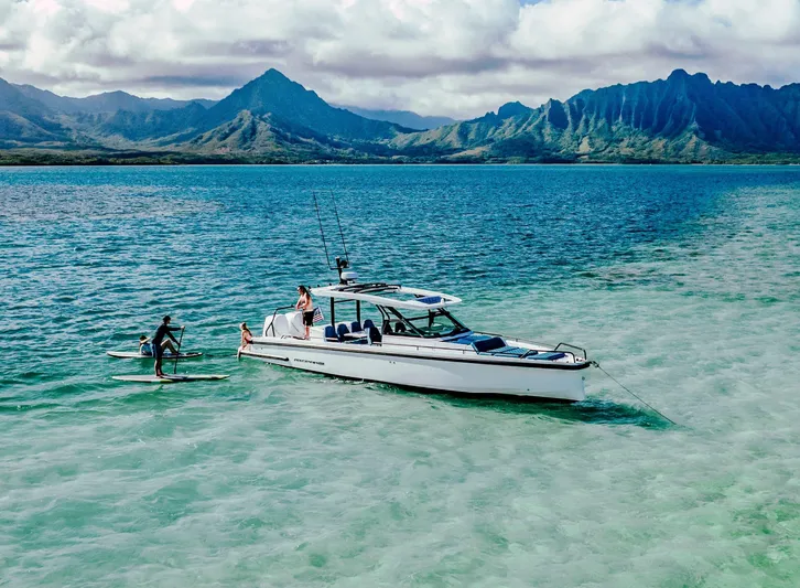  Yacht Photos Pics 2024 Axopar 37 Sun Top boat in scenic tropical waters with mountains.