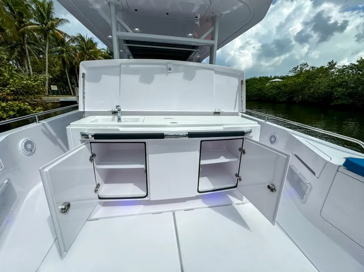  Yacht Photos Pics 2024 Axopar 37 Sun Top boat with open storage compartments and sleek design.