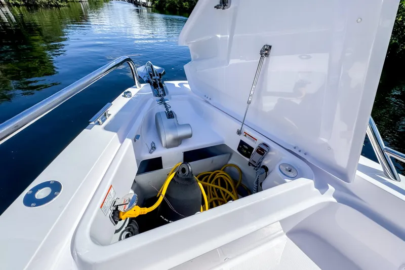  Yacht Photos Pics 2024 Axopar 37 Sun Top boat storage compartment with equipment and yellow hose.