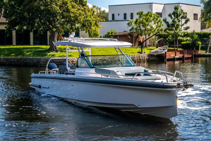  Yacht Photos Pics 2024 Axopar 37 Sun Top boat cruising on a scenic waterway.