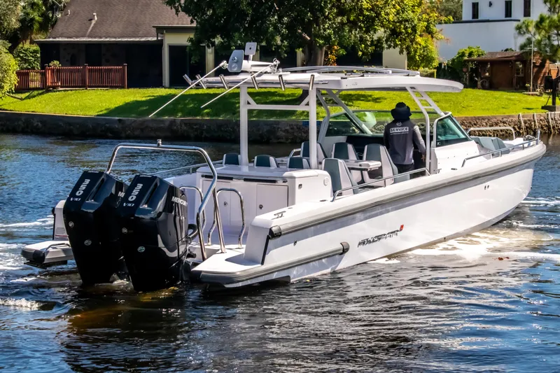  Yacht Photos Pics 2024 Axopar 37 Sun Top boat cruising on a scenic waterway.