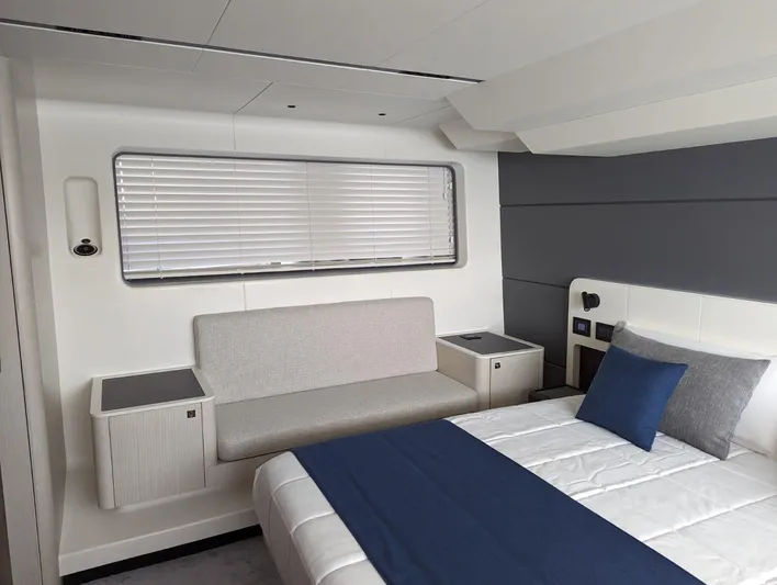  Yacht Photos Pics Modern bedroom interior of 2024 Astondoa AS5 yacht with bed, sofa, and window blinds.