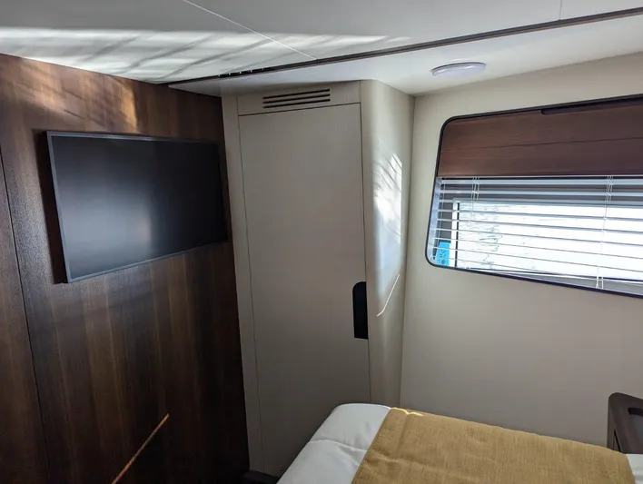  Yacht Photos Pics Astondoa AS5 2024 yacht interior cabin with TV, wardrobe, and window blinds.