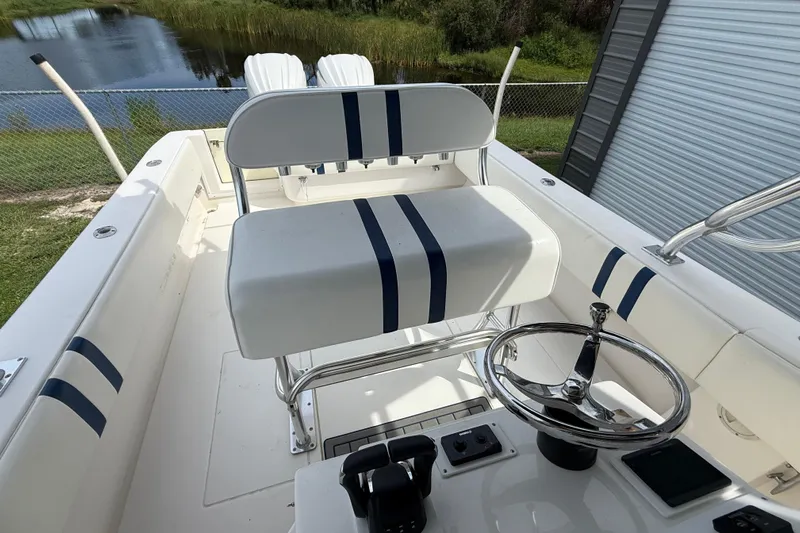  Yacht Photos Pics 2008 Contender 31 Cuddy boat interior with steering wheel and seating, near a lake.