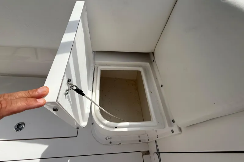  Yacht Photos Pics Open storage compartment on 2008 Contender 31 Cuddy boat, featuring white interior.