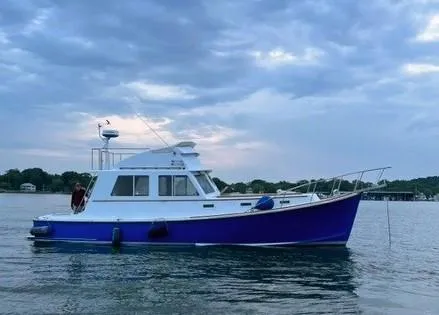 Hi Yo Silver Yacht Photos Pics 1990 Pettegrow 36 Flybridge boat on calm water under cloudy sky.