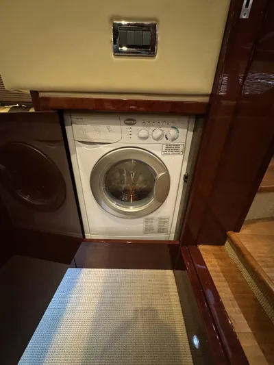 Costas Yacht Photos Pics Washing machine inside 2015 Sea Ray 540 Sundancer yacht, featuring elegant wood paneling.