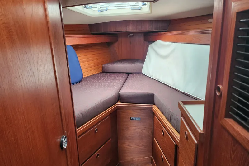 Isola Bella Yacht Photos Pics Cozy cabin interior of 1988 Sabre 42 sailboat with wooden finish and cushioned seating.