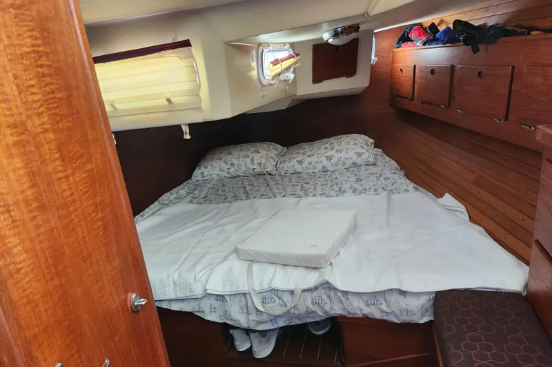 Isola Bella Yacht Photos Pics Cozy cabin interior of 1988 Sabre 42 sailboat with wooden finish and bed.